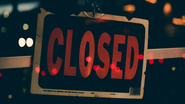 Rotes Schild mit der Aufschrift „Closed“ vor nächtlichen Lichtern – Pornoseiten gesperrt in Deutschland?