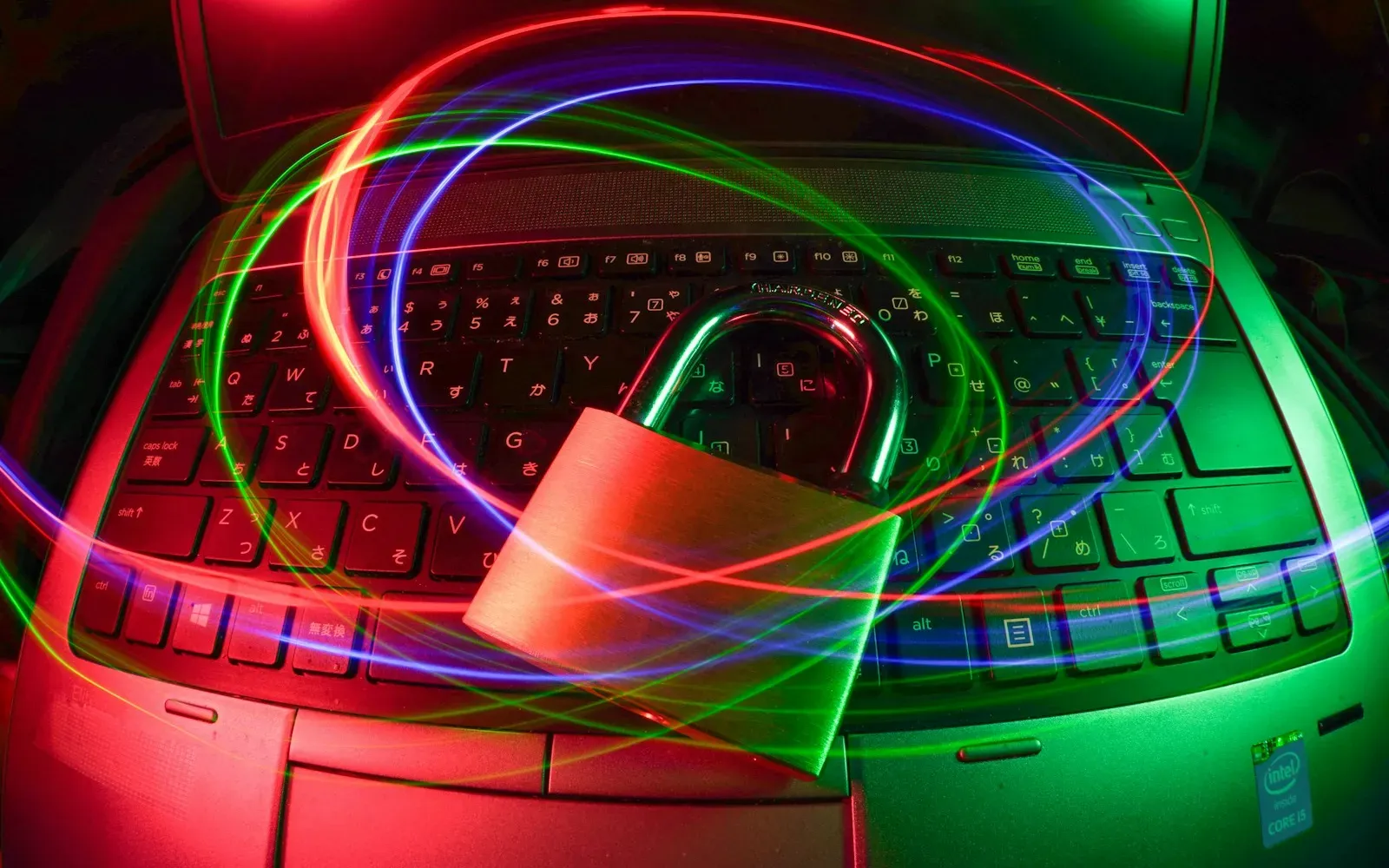 Vorhängeschloss auf einer Laptop-Tastatur mit Lichtspuren – Pornos sicher schauen