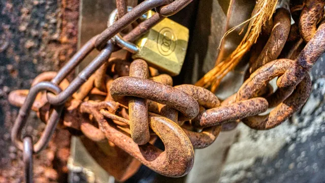 Rostige Kette mit Vorhängeschloss an einem Tor – Pimpbunny Erfahrungen, Leaks und Risiken